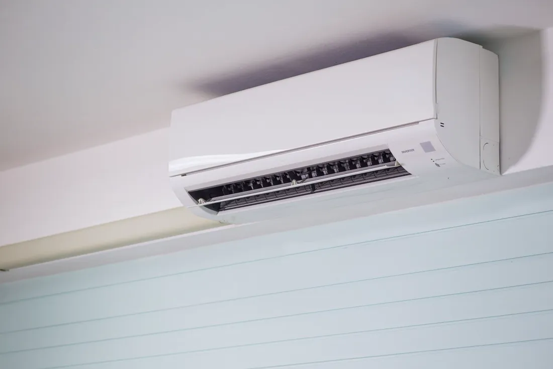 Split de aire acondicionado blanco instalado en lo alto de una pared